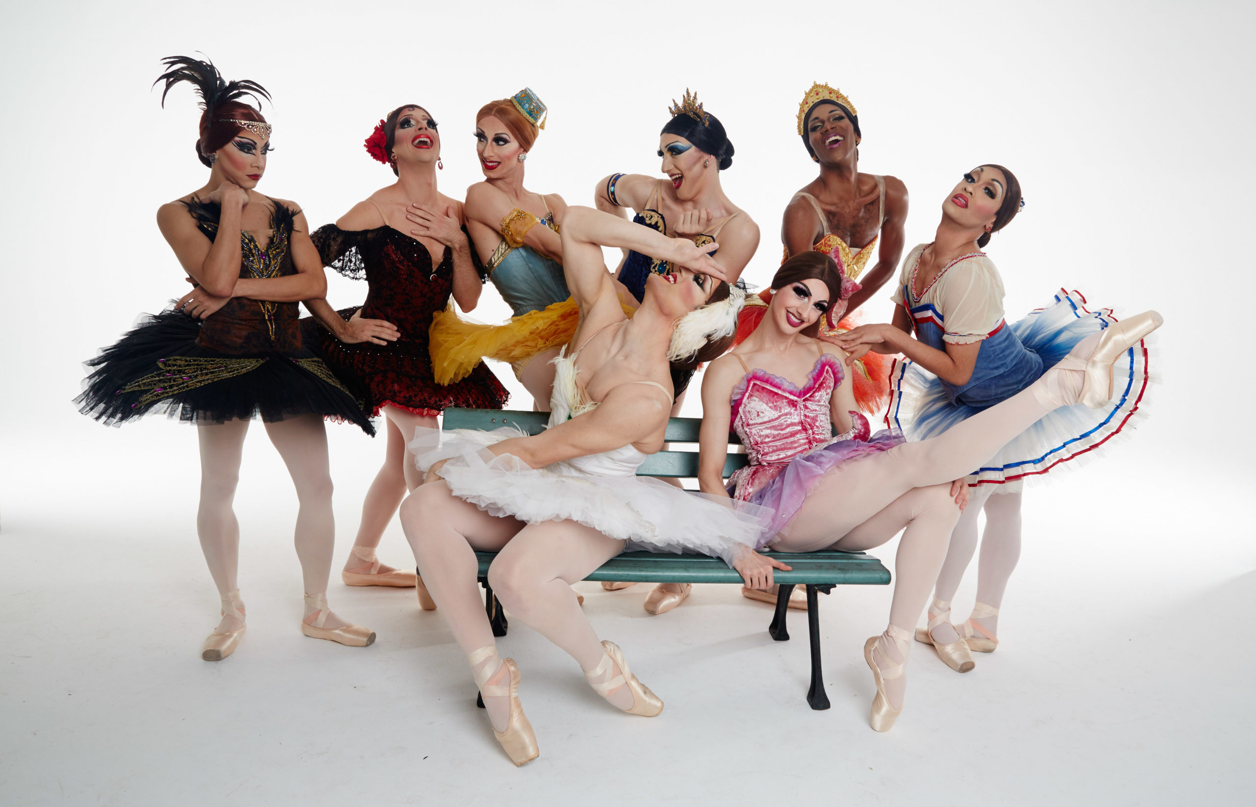 The all-male cast of Les Ballet Trockadero, dressed in their tutus and pointe shoes, posing for the camera.