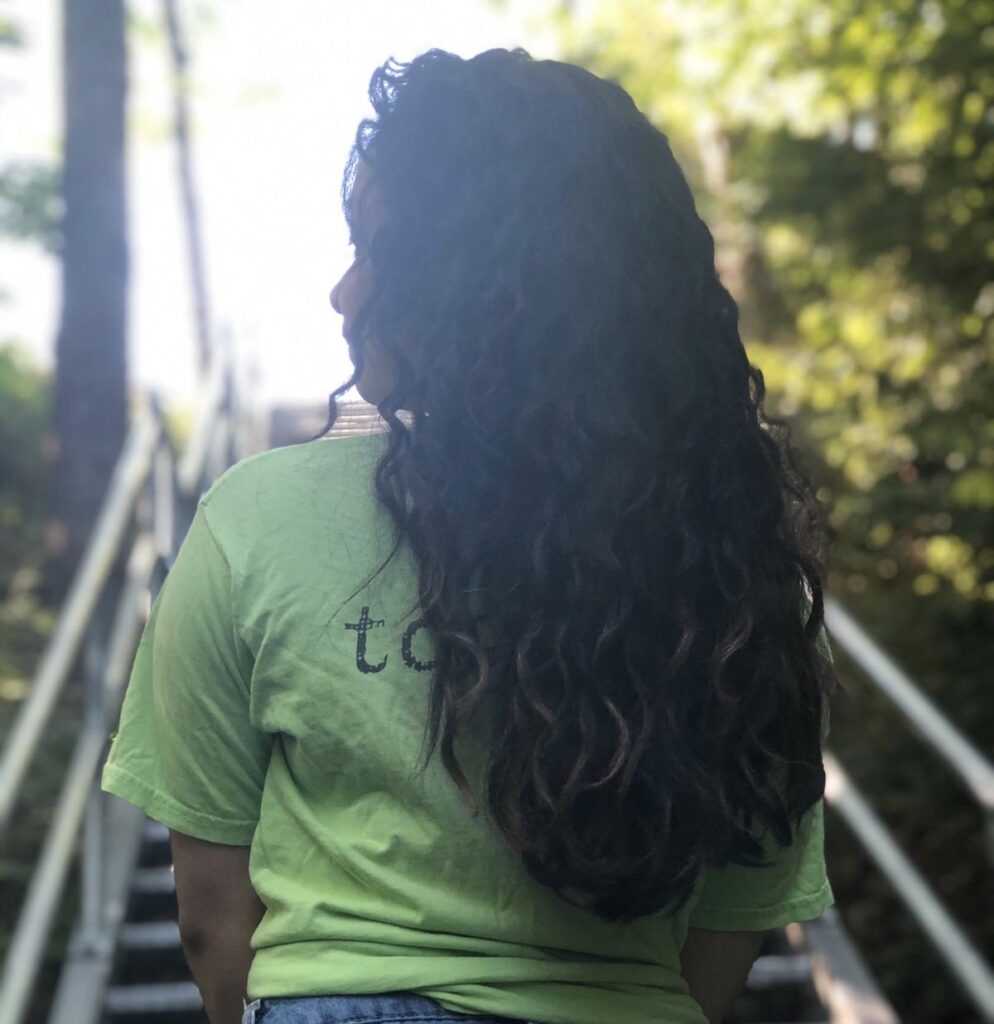 Author faces away from camera with her curly, healthy hair in focus. 