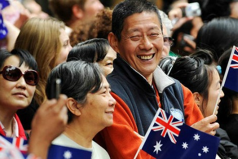 asian australians smiling and holding australian flag