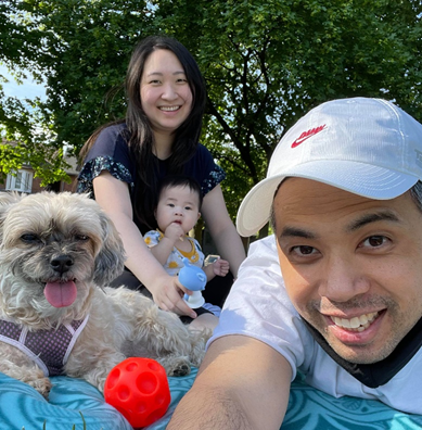 Multicultural family: Filipino dad with Taiwanese mother holding their young son on her lap. A dog is next to the father. 