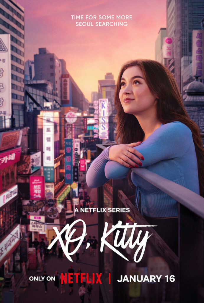 A promotional poster for the Netflix series XO, Kitty. The image features a young woman with long brown hair, leaning on a railing and gazing into the distance with a dreamy smile. She is wearing a light blue sweater and has red nail polish. The background showcases a bustling cityscape of Seoul at sunset, filled with colorful neon signs and crowded streets. The tagline at the top reads, "Time for some more Seoul searching." The series title, XO, Kitty, is written in bold, stylish script, and the text at the bottom announces, "Only on Netflix | January 16." The atmosphere is vibrant and inviting, emphasizing the show's urban and adventurous setting.