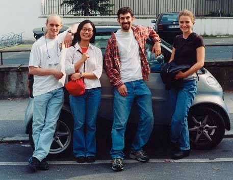 The Chiara String Quartet posing in front of a smart car in Germany in the year 2000