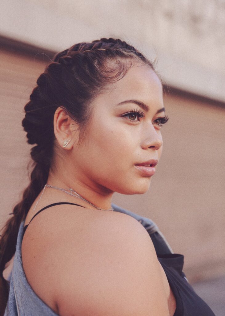 Catherine Li looks off to the side. Her hair is in a knot. 