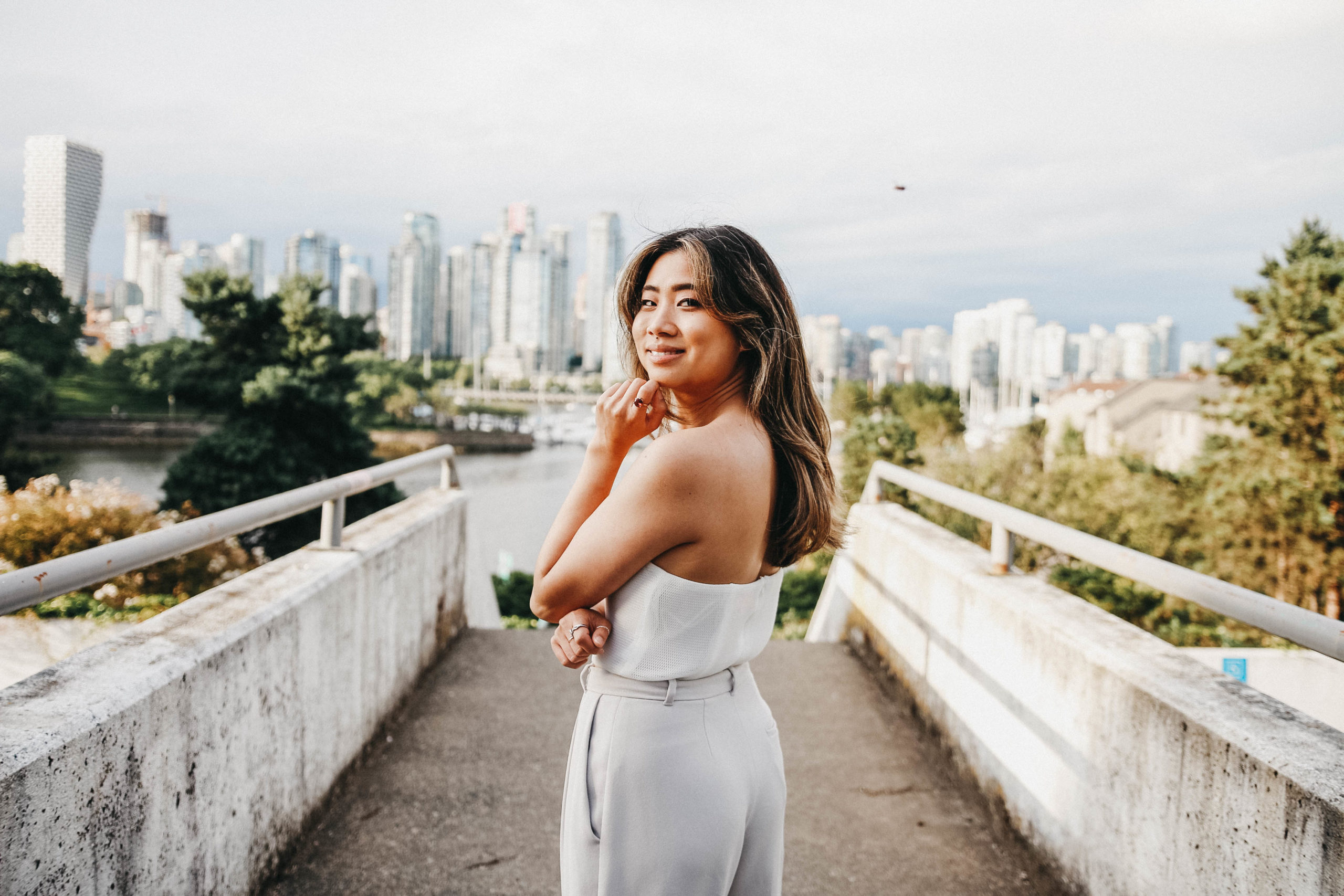 Woman wearing white looking back at camera in front of stairwell