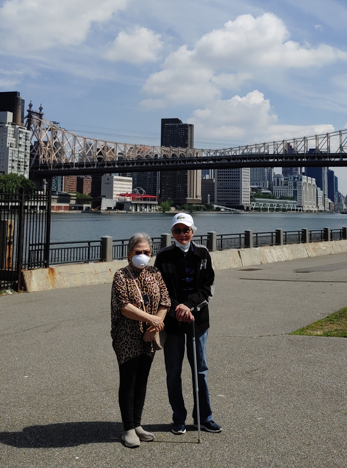 A present-day photo of grandparents in front of a bridge.