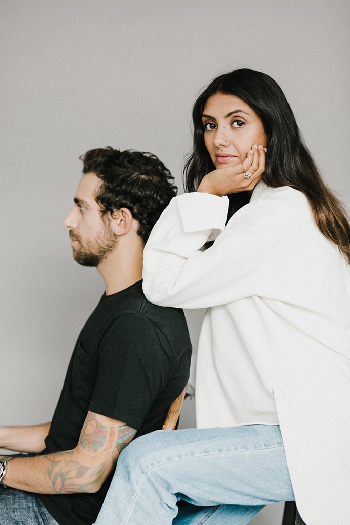 Woodlot co-founder Sonia Chhinji looking at the camera, standing behind co-founder Fouad Farraj, sitting in a chair facing the left