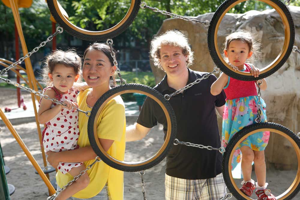Flavia and Luc-Eric, an interracial couple, smiles at the playground