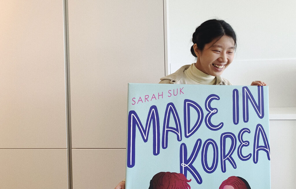 Sarah Suk with the poster of her book Made in Korea