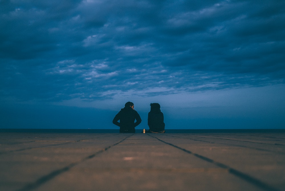 Two people talking on a cloudy day