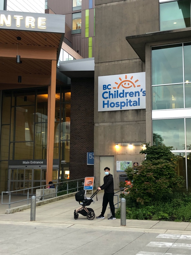 Katrina's husband masked up with a baby stroller outside the hospital