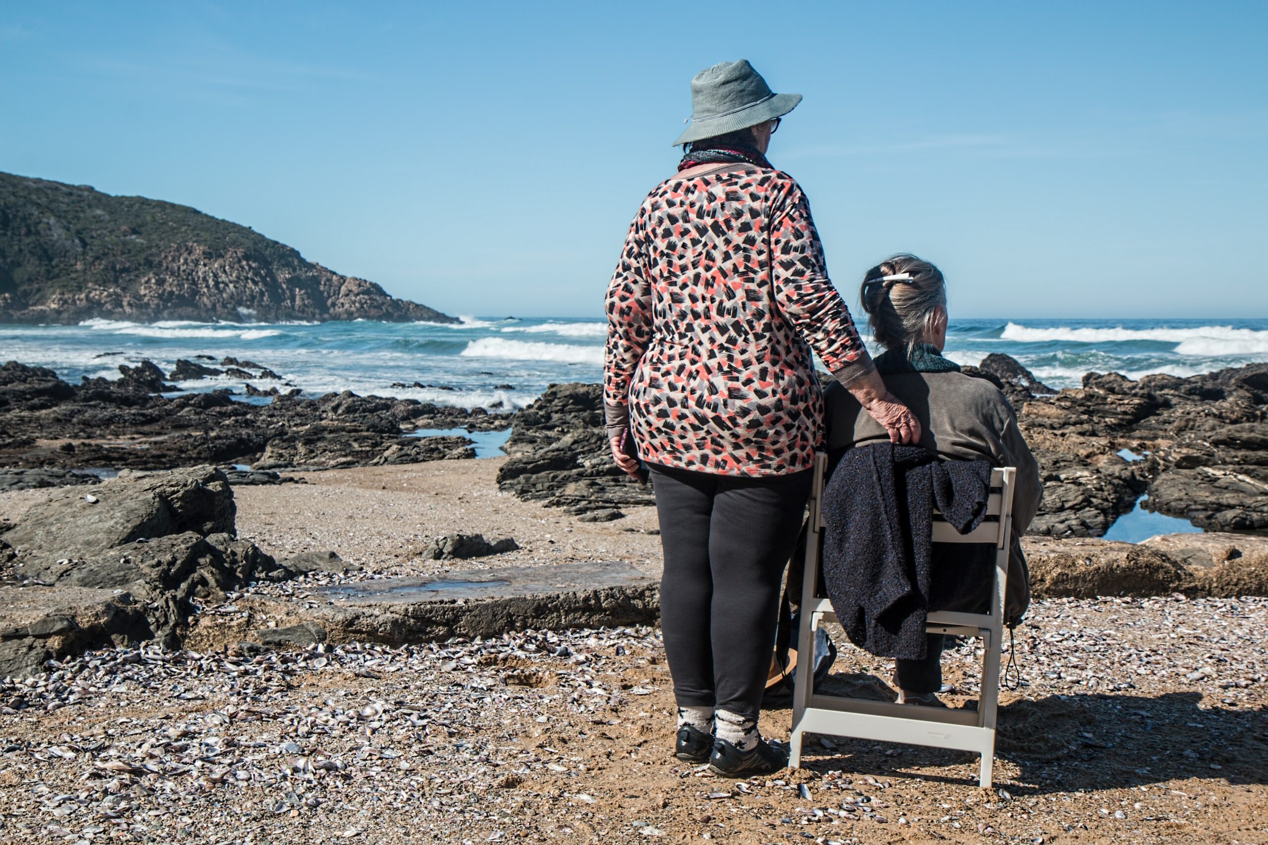 Elderly women sitting by the ocean pondering their immigration experience