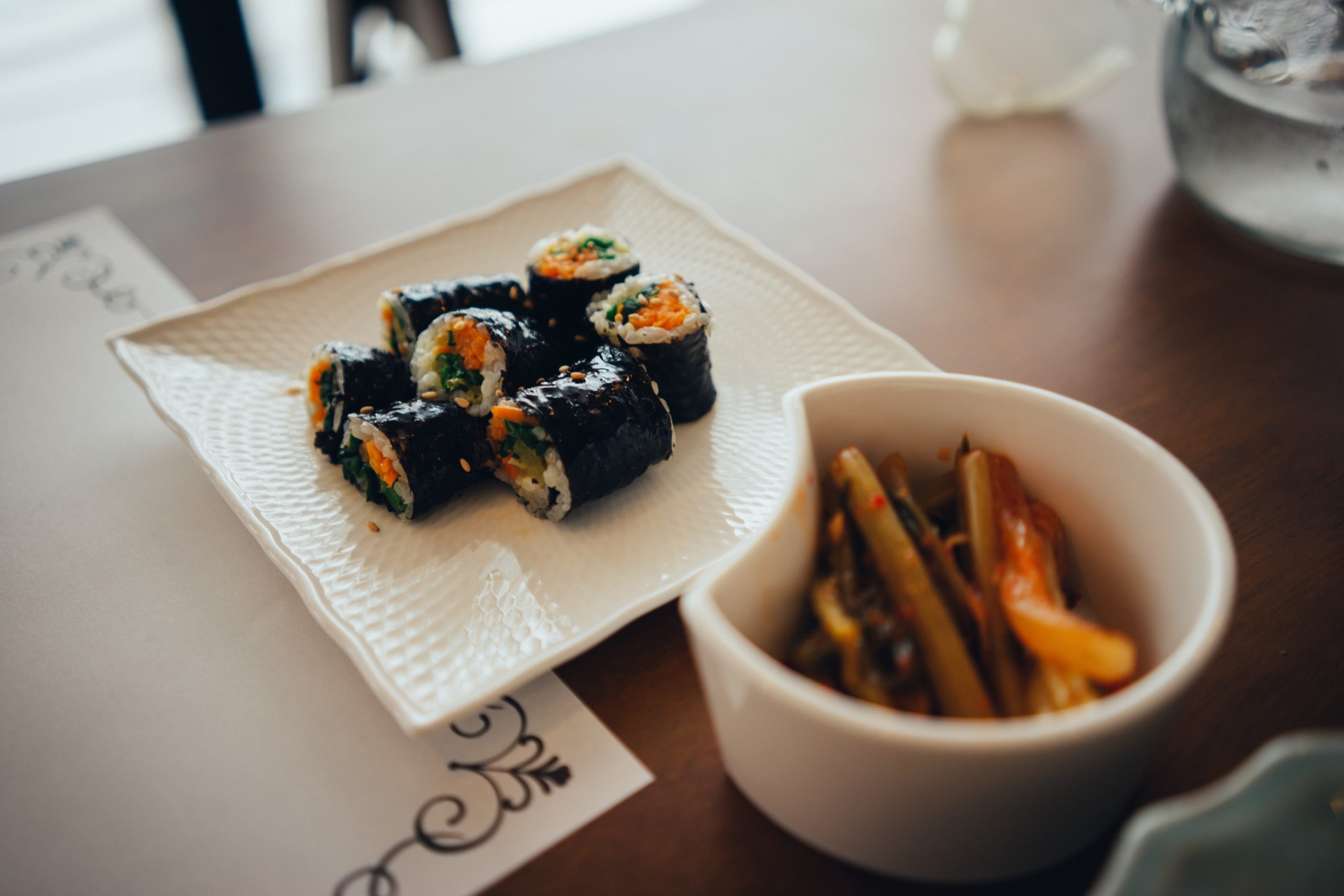 Korean comfort food kimbap and banchan on a table