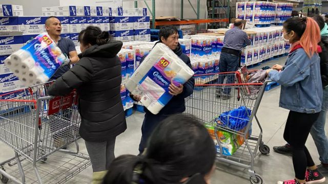 A group of people easily identifiable as East Asian workers workers ration toilet paper to one package per Costco member in an effort to stem hoarding due to fears of coronavirus, at a Costco store in Toronto, Ontario, Canada. (Reuters)
