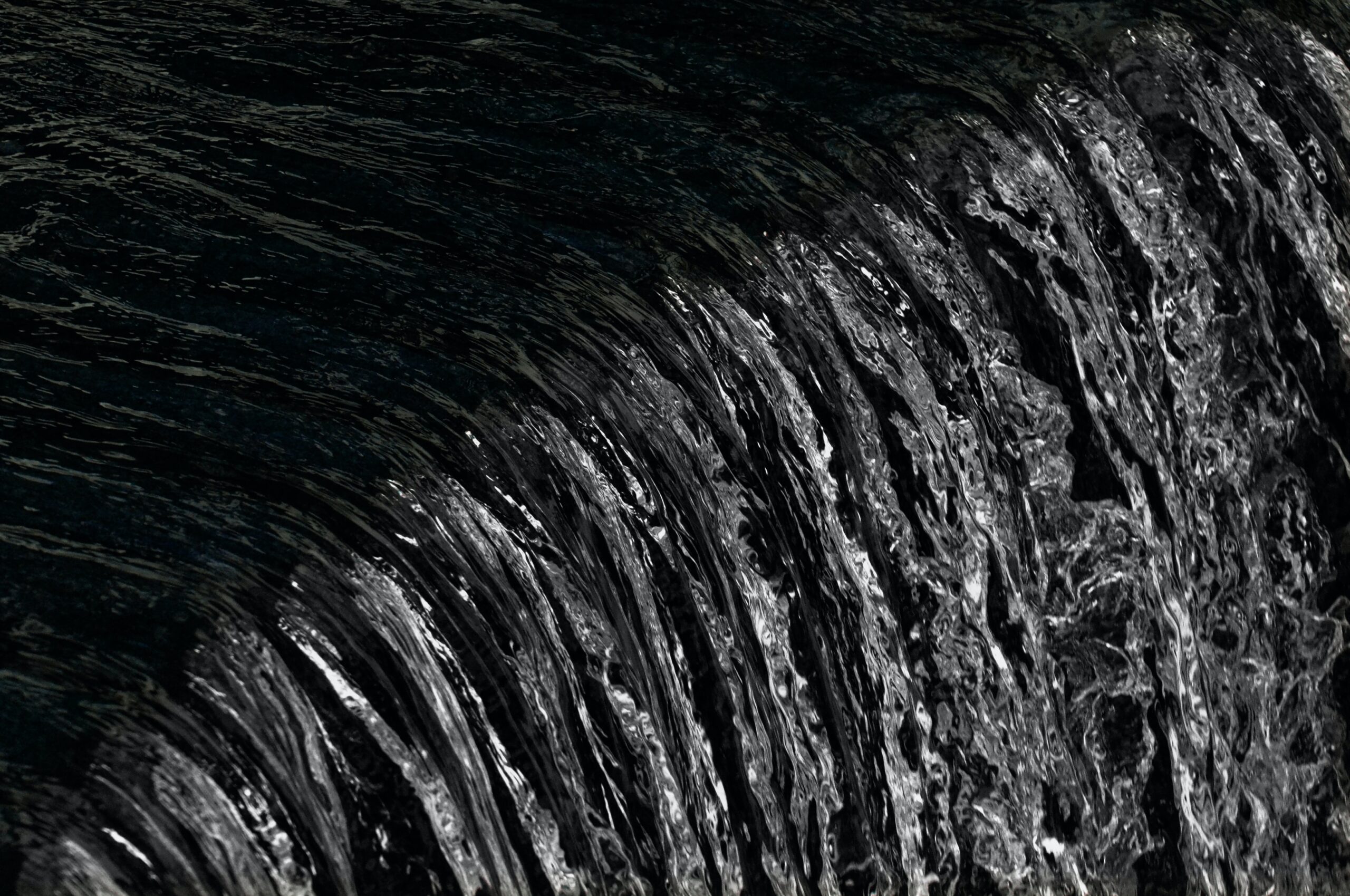 Running water against a black backdrop, which symbolizes wealth in feng shui.